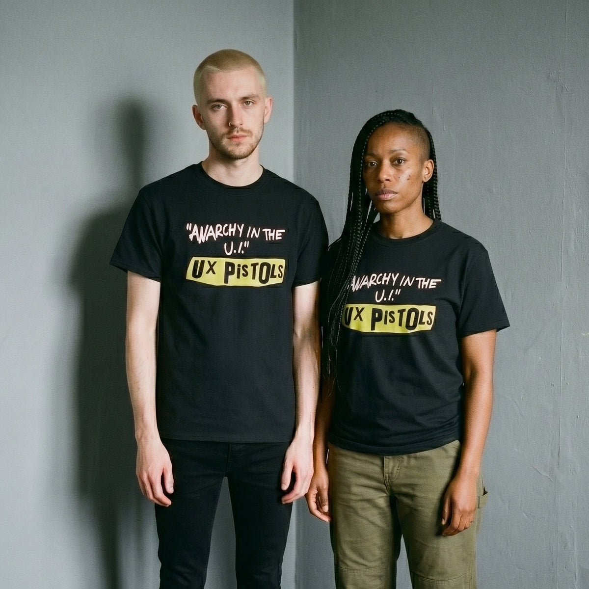 Two models wearing the UX Pistols black graphic tee