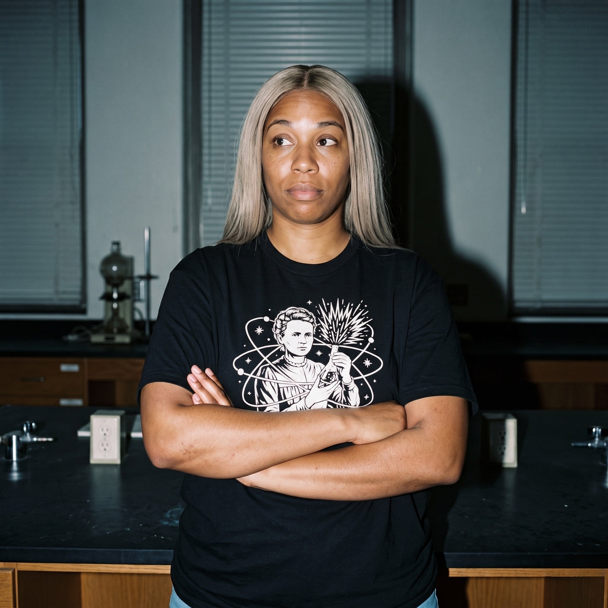 Woman wearing the Breaking Atoms Marie Curie black graphic tee