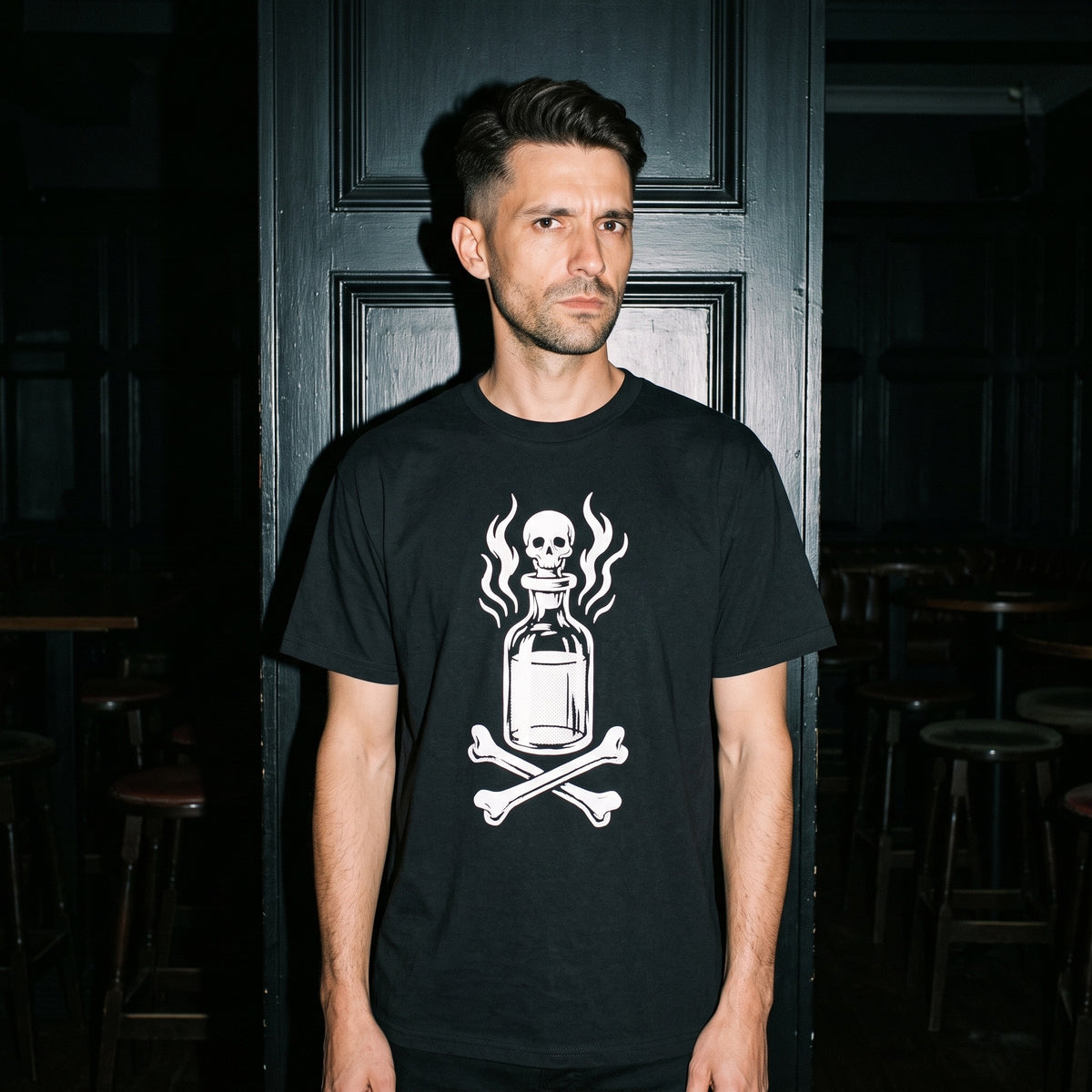 Man wearing the Drink Your Poison black graphic tee