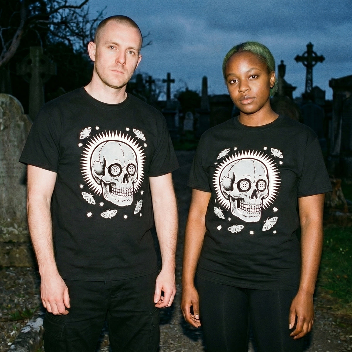 Two models wearing the Memento Vivere black graphic tee