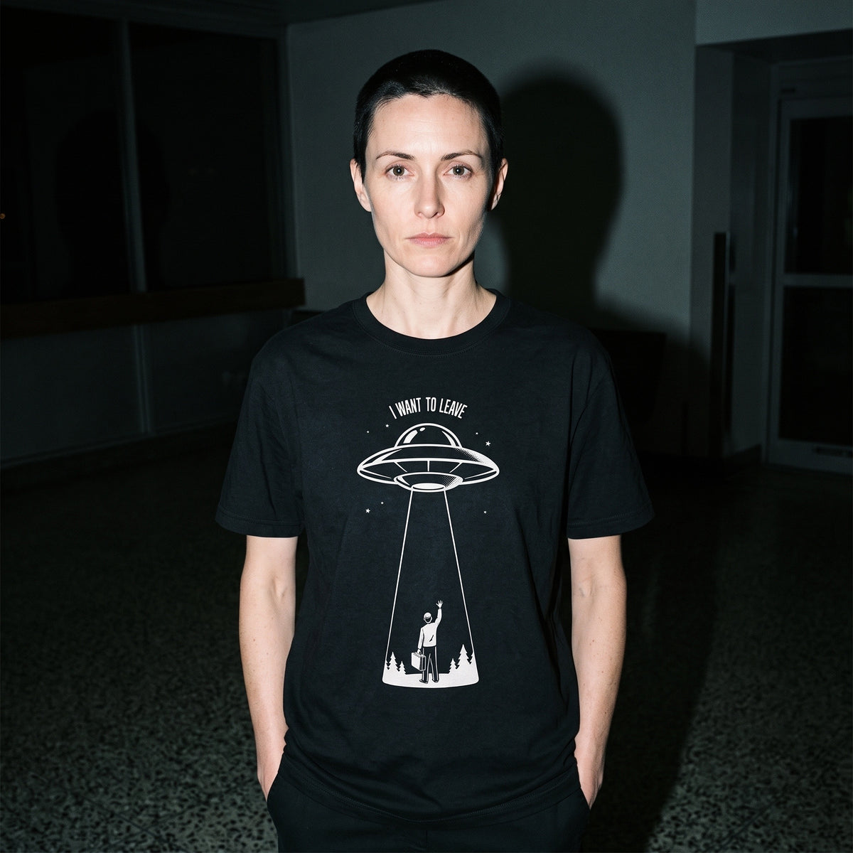 Woman wearing the I Want to Leave black graphic tee
