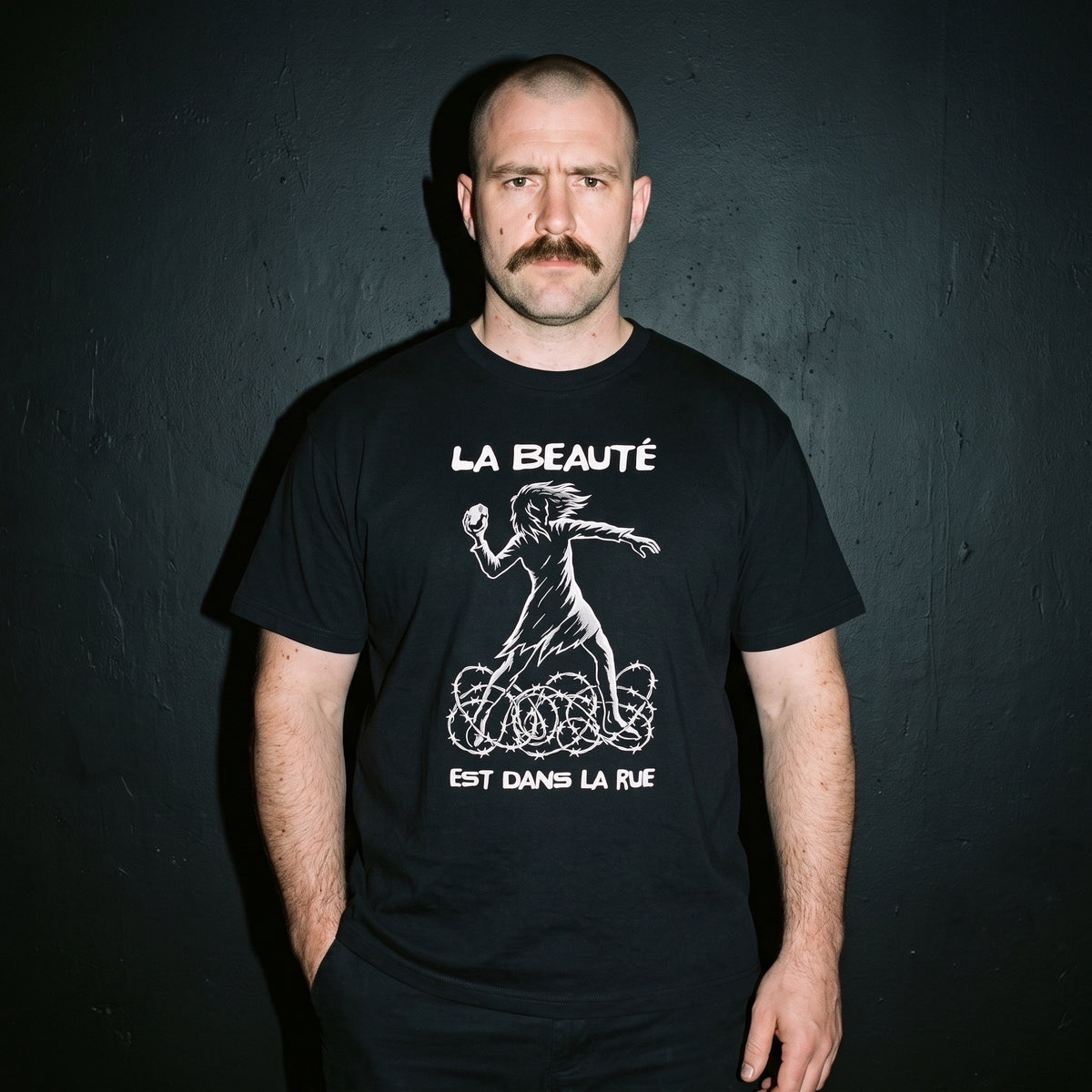 Man wearing the La Beauté est dans la Rue black graphic tee