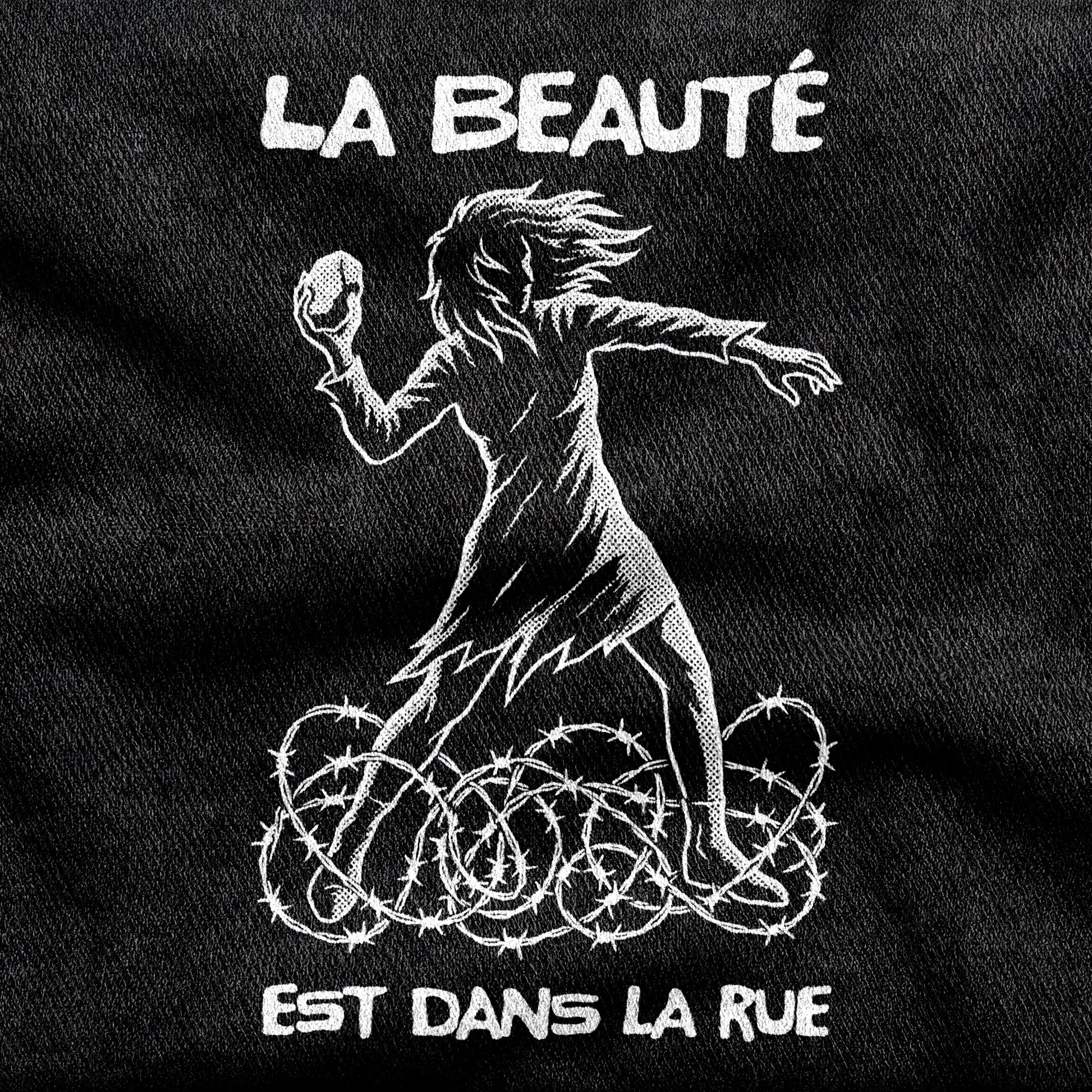 La Beauté est dans la Rue design printed on a black cotton tee, close-up
