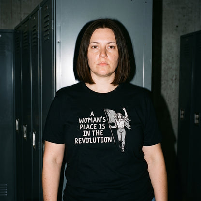 Woman wearing the A Woman's Place is in the Revolution black graphic tee