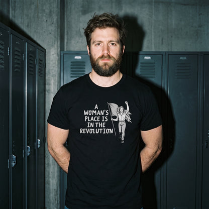 Man wearing the A Woman's Place is in the Revolution black graphic tee