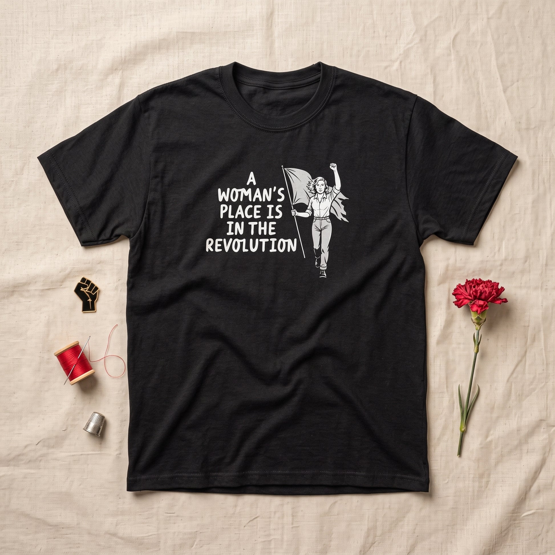 A Woman's Place is in the Revolution black graphic tee, styled flat lay
