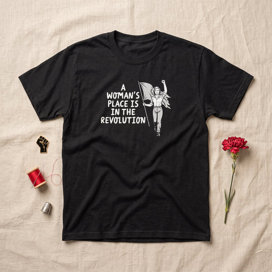 A Woman's Place is in the Revolution black graphic tee, styled flat lay