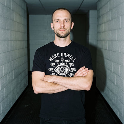 Man wearing the Make Orwell Fiction Again black graphic tee