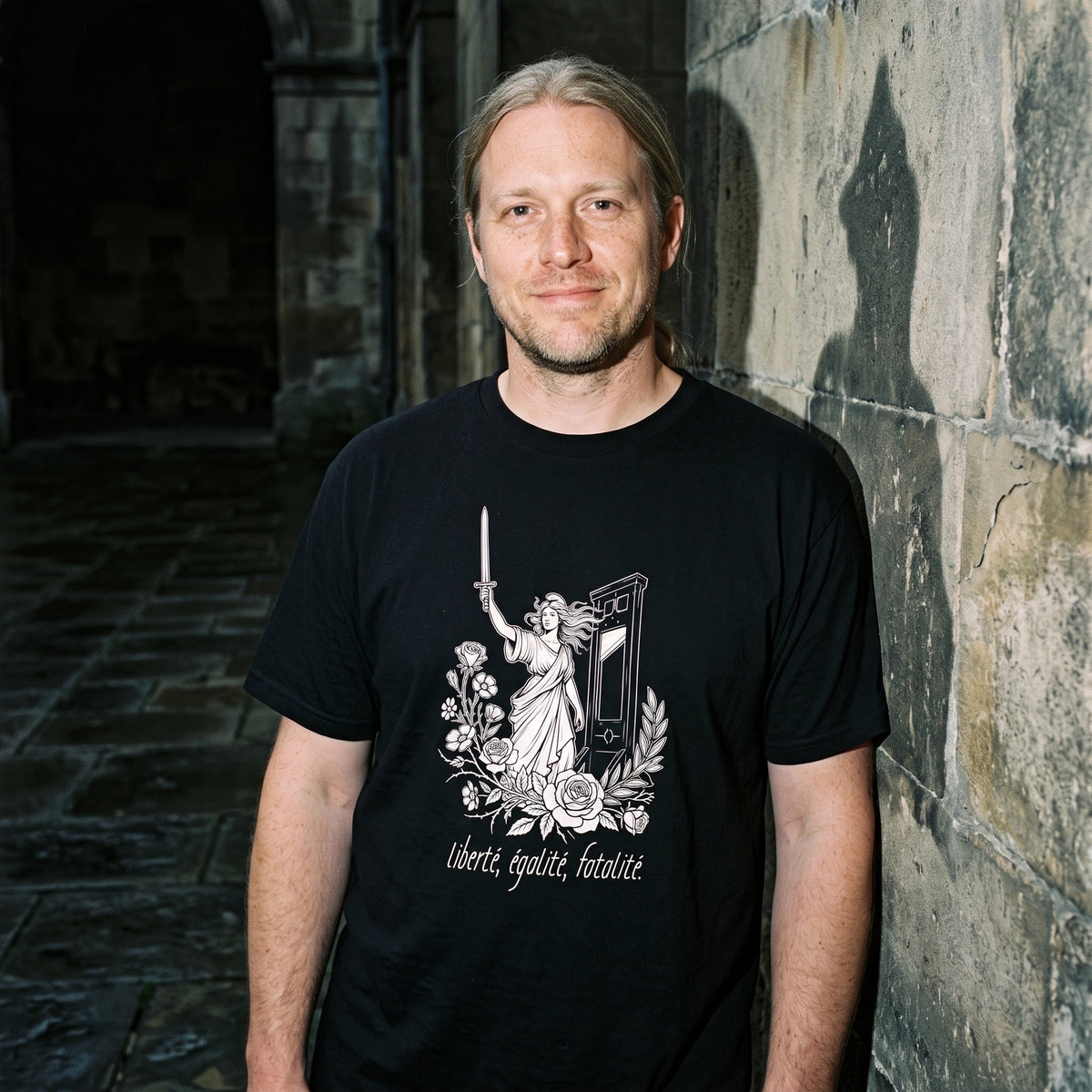 Man wearing the Liberté Égalité Fatalité black graphic tee