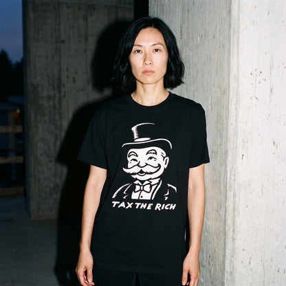 Woman wearing the Tax the Rich black graphic tee