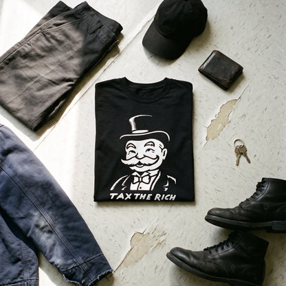 Tax the Rich black graphic tee styled in a flat lay with matching pieces