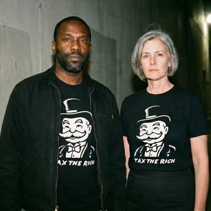 Two models wearing the Tax the Rich black graphic tee