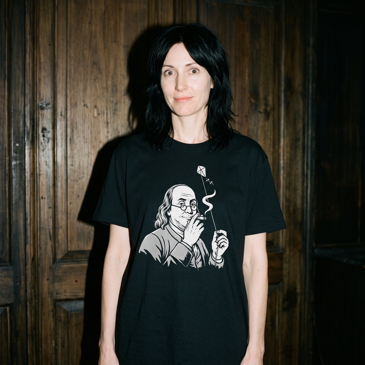 Woman wearing the Benjamin Franklin High as a Kite black graphic tee