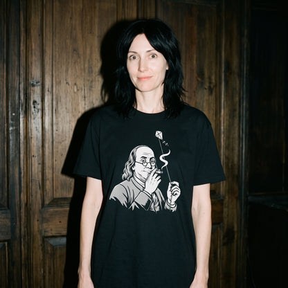 Woman wearing the Benjamin Franklin High as a Kite black graphic tee