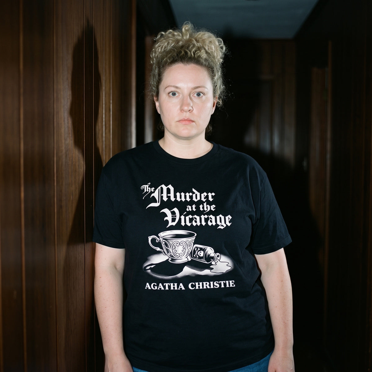 Woman wearing the Murder at the Vicarage Agatha Christie black graphic tee