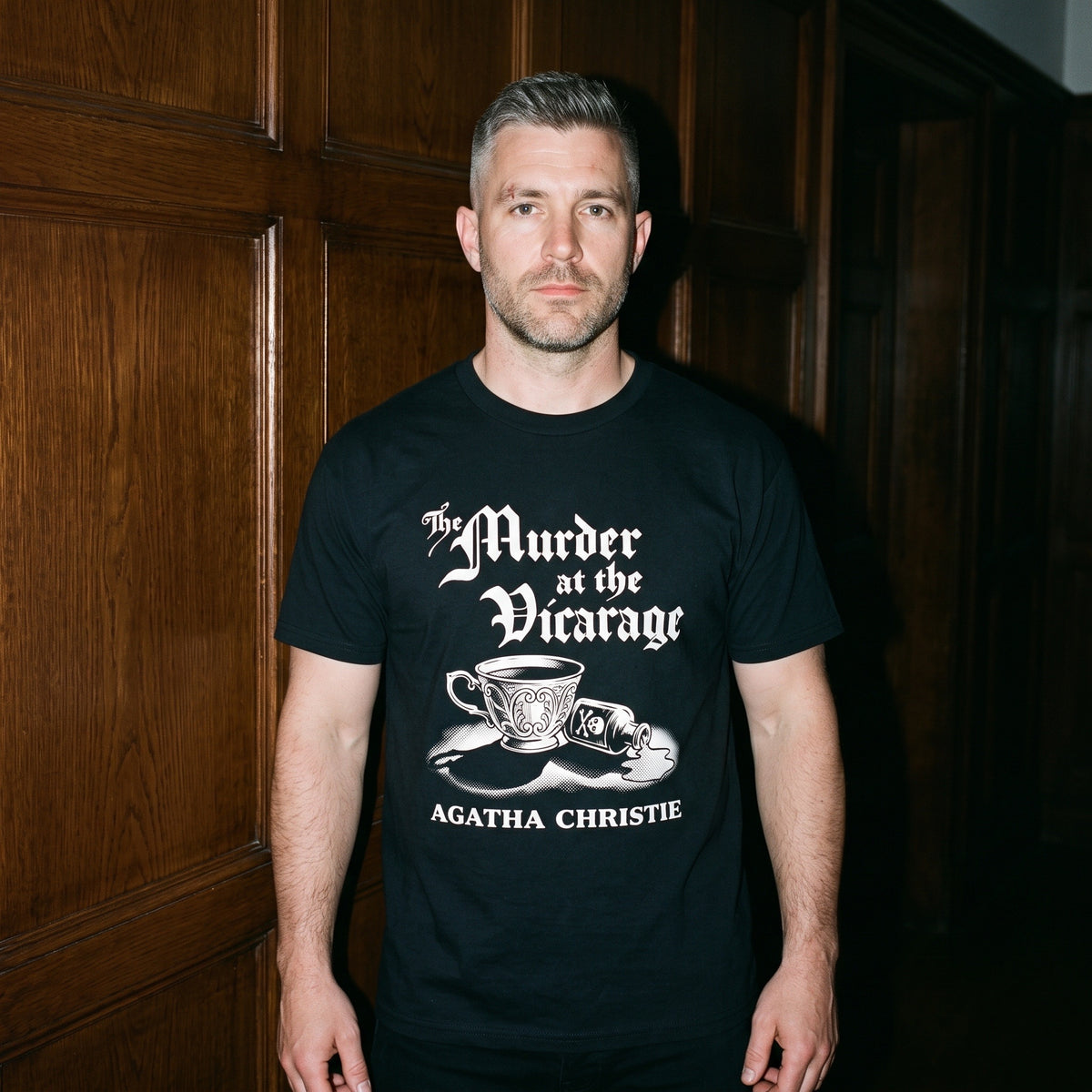 Man wearing the Murder at the Vicarage Agatha Christie black graphic tee