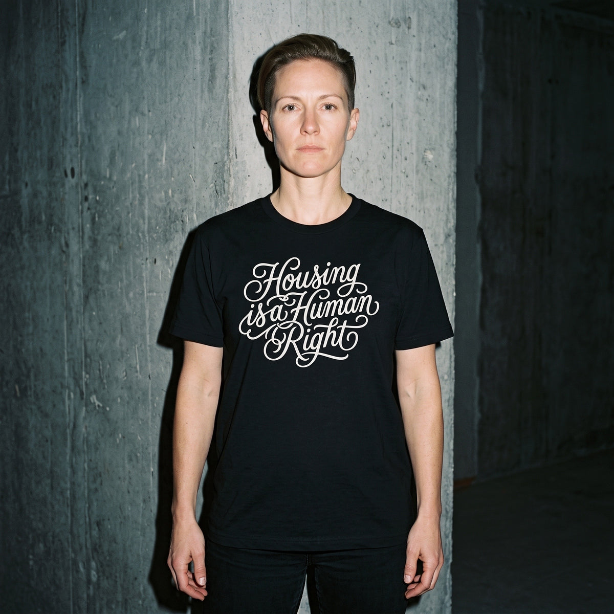 Woman wearing the Housing is a Human Right black graphic tee