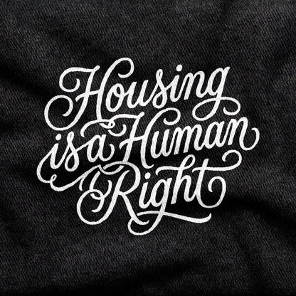 Housing is a Human Right design printed on a black cotton tee, close-up
