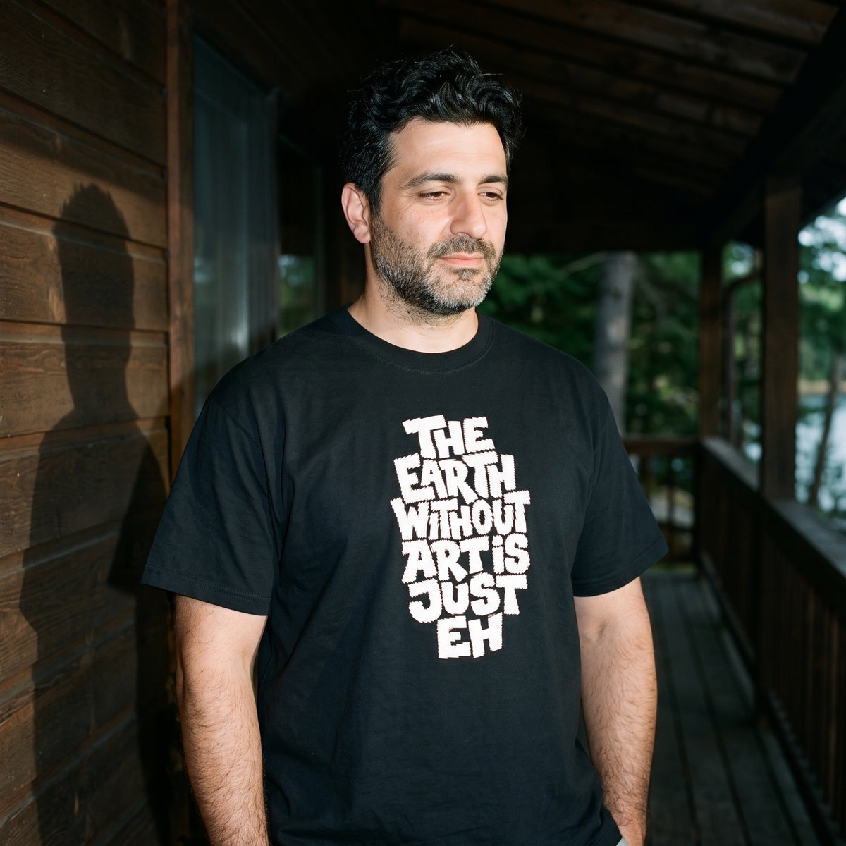 Man wearing the The Earth Without Art is Just Eh black graphic tee