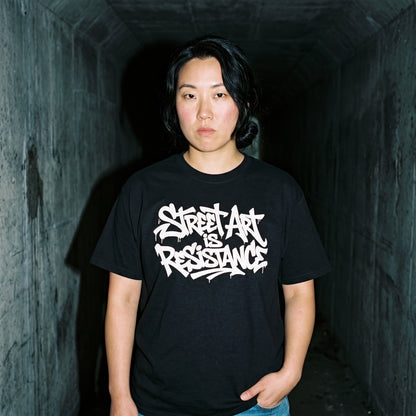 Woman wearing the Street Art is Resistance black graphic tee