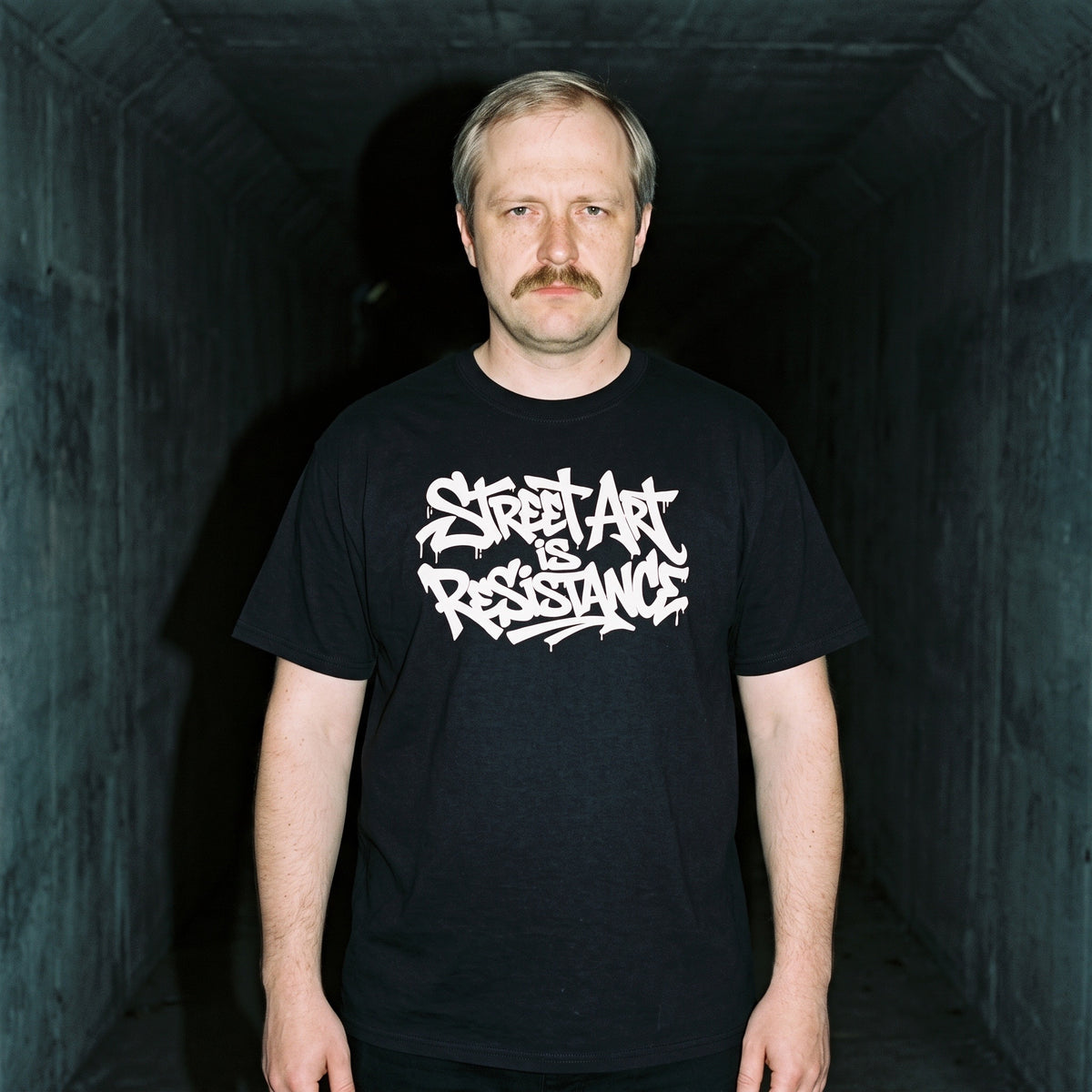 Man wearing the Street Art is Resistance black graphic tee