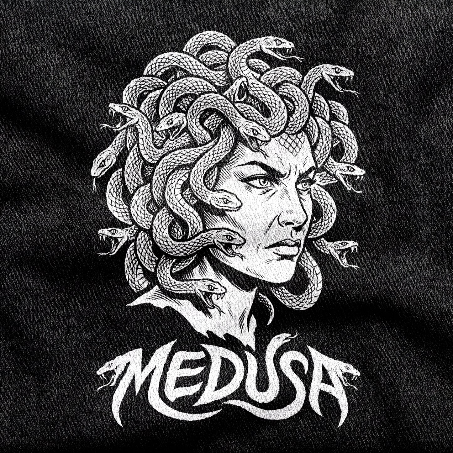Medusa design printed on a black cotton tee, close-up