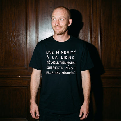 Man wearing the Une Minorité à la Ligne Révolutionnaire Correcte n'est plus une Minorité black graphic tee