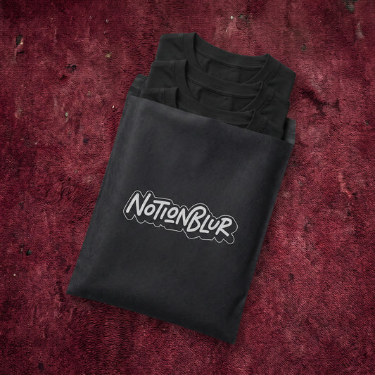 Three folded Notionblur tees in a black mailer on crimson cinema carpet