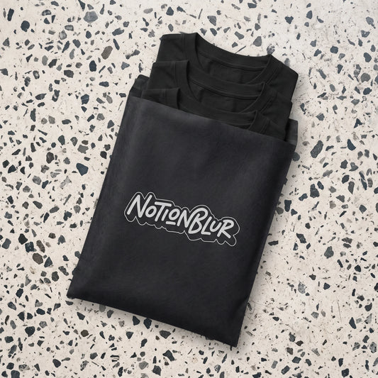 Three folded Notionblur tees in a black mailer on pale terrazzo